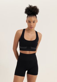 Even&Odd active MEDIUM SUPPORT SEAMLESS SPORTS BRA WITH CUT OUT RACER BACK - Sujetadores deportivos con sujeción media - black