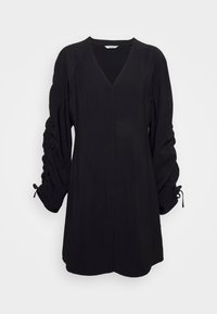 Robe noire col en V avec manches longues froncées et détails de lien aux poignets, longueur genou et silhouette ajustée.