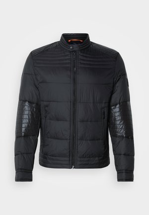 Chaqueta puffer negra con cierre de cremallera, cuello alzado y paneles de hombros brillantes en contraste. Textura de acolchado horizontal en toda la prenda.
