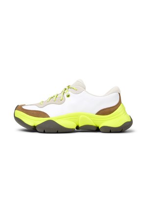 Baskets blanches avec des accents jaunes, détails en daim marron et lacets verts ; semelle épaisse avec une bande en caoutchouc grise et un design de bout rond.