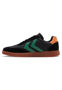 Fekete sneaker zöld chevron díszítéssel, velúr és szintetikus felsőrésszel, gumitalppal és narancssárga sarkú betéttel.