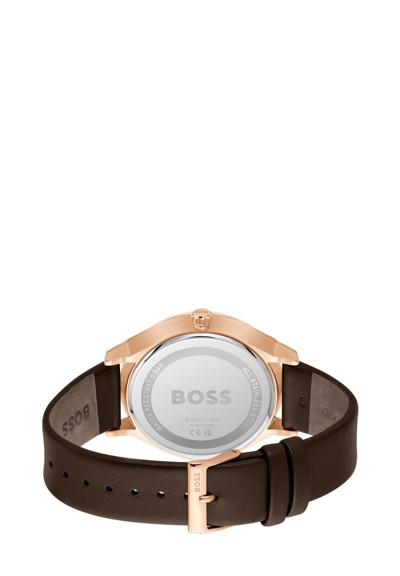 Montre à bracelet en cuir brun avec un boîtier en acier inoxydable rose doré. Le dos rond en argent présente un texte gravé, y compris le logo de la marque "BOSS".