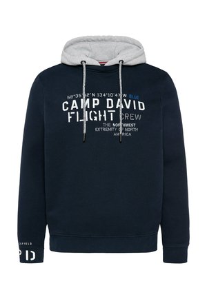 Sudadera marina con forro gris, presentada con texto blanco y azul, cordones ajustables y puños acanalados. Muestra logotipos y coordenadas geográficas.