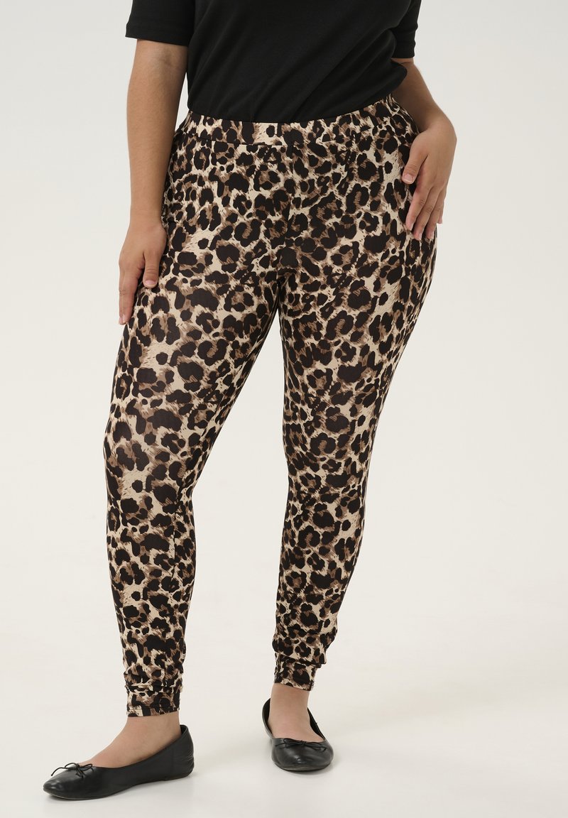 Leopardenmuster Leggings aus leichtem Stoff mit elastischem Bund; enganliegendes Design mit Knöchel-Bündchen. Kombiniert mit schwarzen flachen Schuhen.