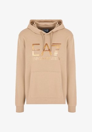 Haut à capuche beige avec cordons de serrage, présentant un logo EA7 métallique doré sur le devant et une poche kangourou. Matériau doux avec des poignets côtelés.