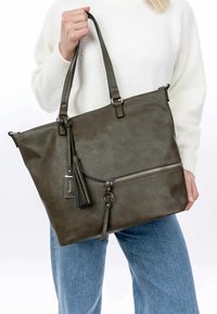 Borsa tote in pelle verde oliva con tasca con zip, pendente a frange e dettagli in argento. Presenta manici doppi e un design strutturato.