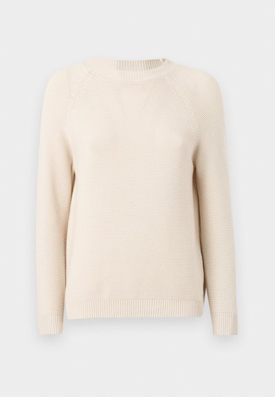 Hele beež kudumine särk, millel on ümmargune kaelus, soonikkoes varrukate otsad ja äär. Tekstuuril on peen muster lisatud detailideks.