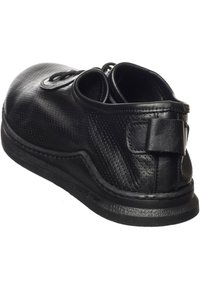 Schwarze Ledersneaker mit strukturierten Oberflächen, Schnürdesign, gepolstertem Kragen und einem kleinen Riemen an der Ferse. Verfügt über eine strapazierfähige Gummisohle.