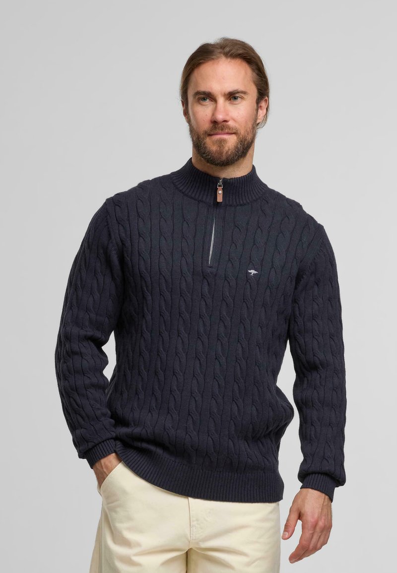 Marineblauwe kabelpatroon trui met een hoge kraag en kwartrits, met ribgebreide manchetten en zoom. Klein logo accentueert de borst.