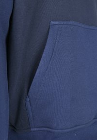 Felpa blu navy con tasca a marsupio. Realizzata in morbido tessuto testurizzato, con polsini e orlo a coste. Design semplice senza motivi.