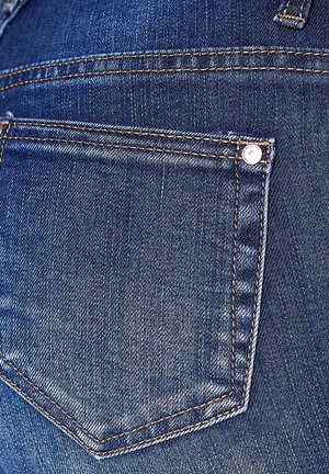Denim jeans met een close-up van de achterzak. Kenmerkt zich door de donkerblauwe kleur, dubbele stiksels en een metalen knoopdetail.