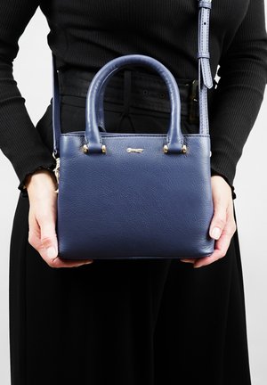 Navy blue leather handbag with two top handles, detachable shoulder strap, gold-tone hardware, and smooth textured surface.