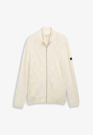 Šviesiai kreminė mezgimo cardigan palaidinė su rombo raštais, įgludinta apykakle, rankovių ir apačios apdaila, su sidabro spalvos užtrauktuku ir dviem priekinėmis kišenėmis.