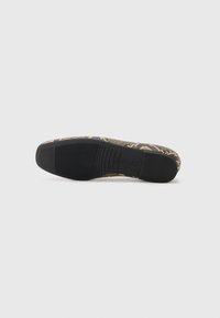 Schwarze Gummisohle mit strukturiertem Grip. Das Obermaterial zeigt ein grün-beiges Kreuzmuster, das einen gewebten Look erzeugt. Rund geschnittene Zehenpartie.