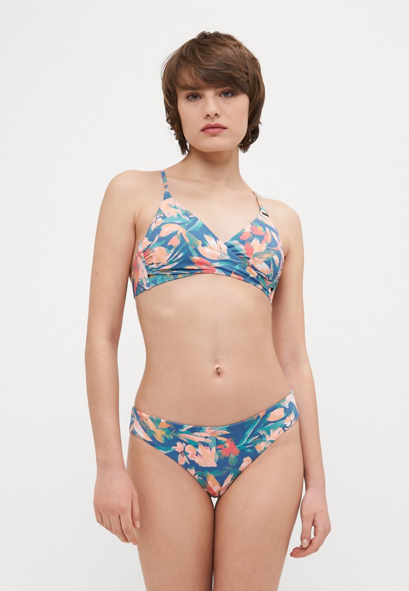 Bikini à motif floral avec une base bleue, agrémentée d'accents roses et verts. Le haut possède des bretelles réglables et un design enveloppant. Le bas est de coupe haute.