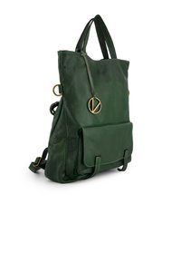 Grüne Leder-Umhängetasche mit strukturierter Oberfläche, hat zwei Griffe, eine Vordertasche und einen Metallreißverschluss. Mit einem Friedenzeichen-Anhänger.