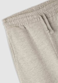 Jasnoszare spodnie dresowe wykonane z miękkiej mieszanki bawełny, wyposażone w elastyczny pas, sznurek do ściągania i boczne kieszenie. Gładka faktura, casualowy design.