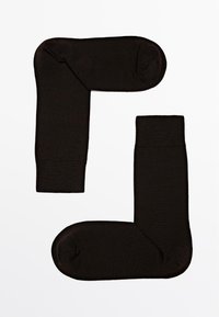 Sorte bomuldsstrømper vist i en "G"-form, med en glat tekstur og ankel-længde design samt forstærket tå og ribkant.