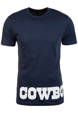 T-shirt bleu marine à manches courtes avec de grandes lettres blanches en bloc épelant « COWBOY » en bas sur le devant.