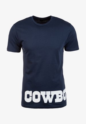 T-shirt bleu marine à manches courtes avec de grandes lettres blanches en bloc épelant « COWBOY » en bas sur le devant.