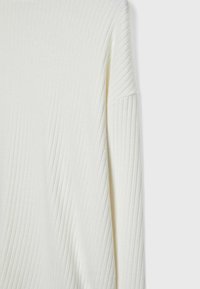 Maglione a coste crema con maniche lunghe. Presenta strisce verticali e un taglio rilassato. Tessuto morbido e leggero. Nessuna ferramenta visibile.