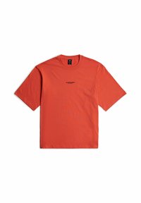 T-shirt di cotone rosso con maniche corte e scollo rotondo, con un piccolo logo nero al centro. Design semplice e senza fronzoli.