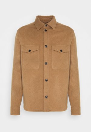 Brown wool-blend shirt jacket with a pointed collar, black buttons, two chest pockets, and a straight cut. Soft texture, minimalistic design.