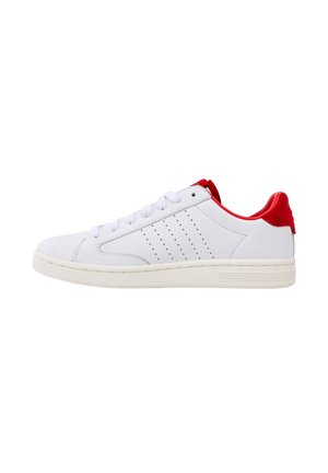 White sneaker with red accents, smooth leather material, rounded toe, flat laces, and perforated detailing on the side.