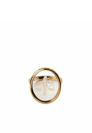 Anillo de oro con una cara oval clara grabada con una figura que sostiene una balanza equilibrada, simbolizando la justicia o el signo zodiacal de Libra.
