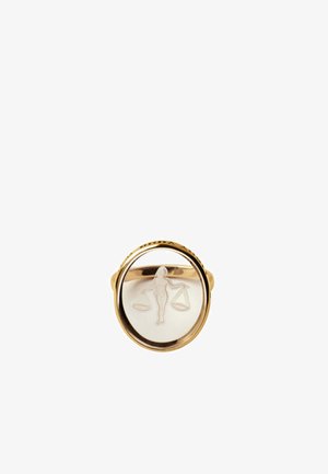 Anillo de oro con una cara oval clara grabada con una figura que sostiene una balanza equilibrada, simbolizando la justicia o el signo zodiacal de Libra.