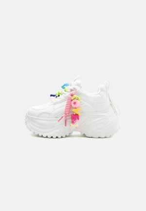 Chunky white sneaker with thick sole and colorful beaded "LOVE" decoration attached to pink shoelace on a plain background.