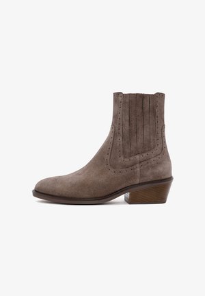 Suede ankle boot in taupe with a pointed toe, subtle stitching, pleated accents on the shaft, and a stacked wooden heel.