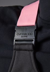 Zwarte stof met een zachte textuur, voorzien van een brede roze band. Een zwarte plastic gespsluiting toont het merk "even&odd ACTIVE."