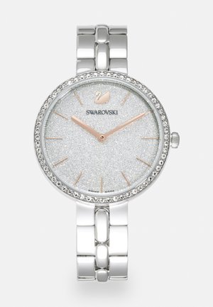 Reloj de metal plateado con una esfera circular, dial plateado texturizado y brillante, manecillas en oro rosado y cristales alrededor del bisel. Presenta una correa de eslabones.