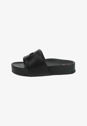 Black slide sandal made of smooth leather; features a wide strap, cushioned footbed, and low, flat sole. Simple design with minimal accents.