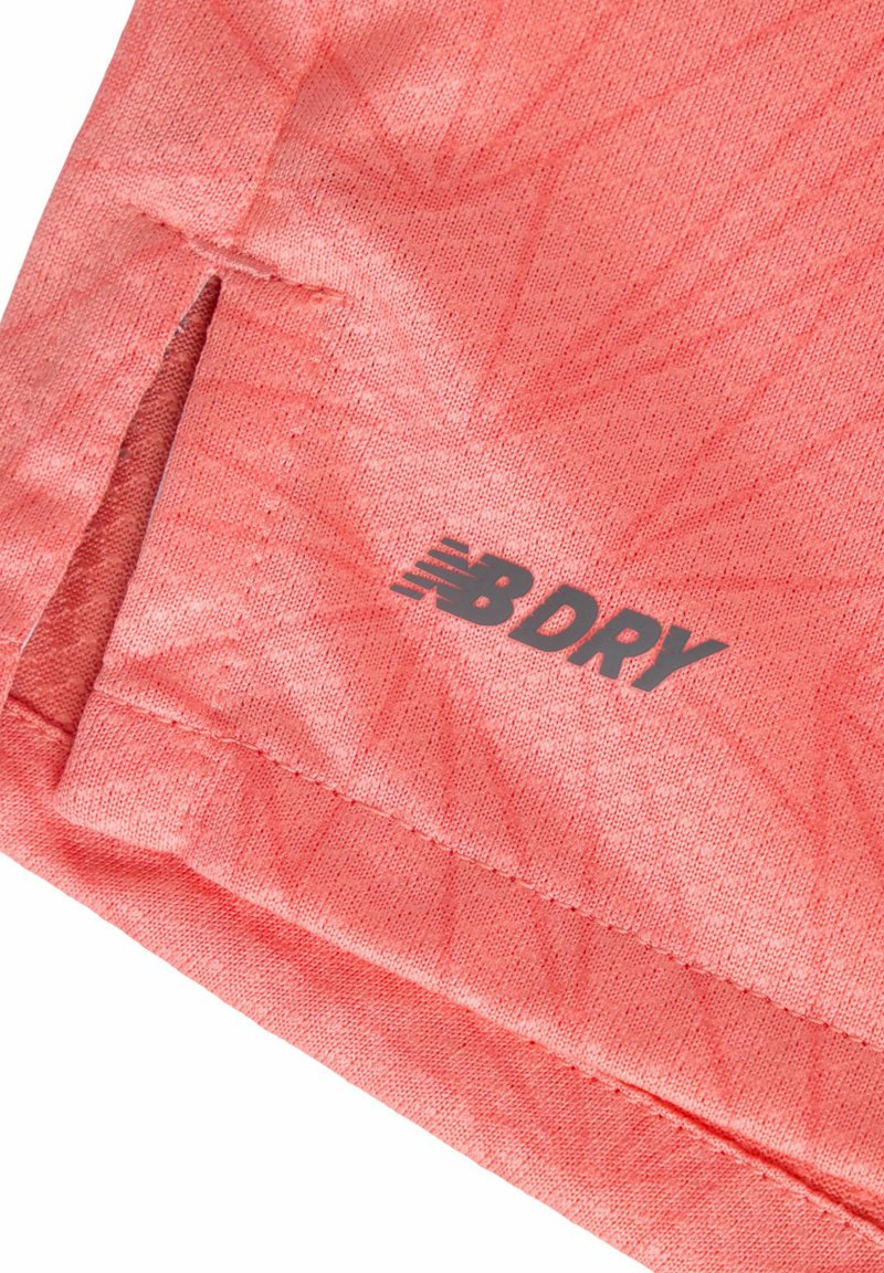 Leichtes korallenrotes Sportgewebe mit strukturierter Oberfläche. Verfügt über einen seitlichen Schlitz am Saum und ein schwarzes "B DRY"-Logo in der Nähe des unteren Randes.