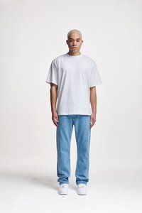 Witte kortebril t-shirt gecombineerd met lichtblauwe denim jeans. De pasvorm is losjes en de schoenen zijn witte sneakers. Eenvoudige en casual uitstraling.