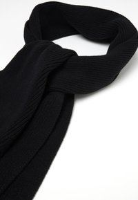 Schwarzer Strickschal mit gerippter Textur, der ein langes und breites Design aufweist. Er ist aufgerollt und locker gebunden, mit gleichmäßigen Kanten.