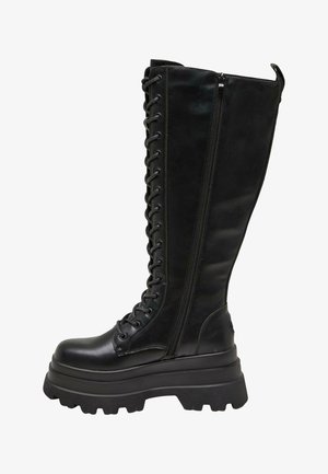 Botas negras hasta la rodilla, hechas de cuero suave, con una cremallera lateral, cordones en la parte frontal y una suela gruesa y resistente.