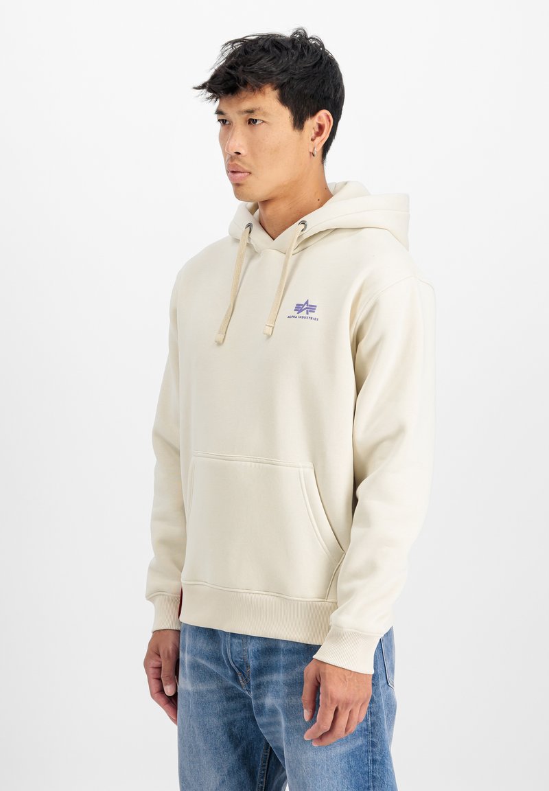 Bežs hoody ar kangaroo kabatu, purpura krāsas logo uz krūšu, ar auklām regulējamu kapuci un ribām apģērbtu piedurknēm. Maiga auduma ar brīvu piegulšanu.