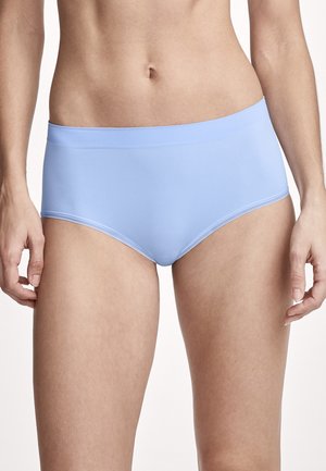 Frau trägt hellblaue nahtlose High-Waist-Slips, gezeigt vom Mittelrücken bis zur Mitte des Oberschenkels vor einfachem Hintergrund.