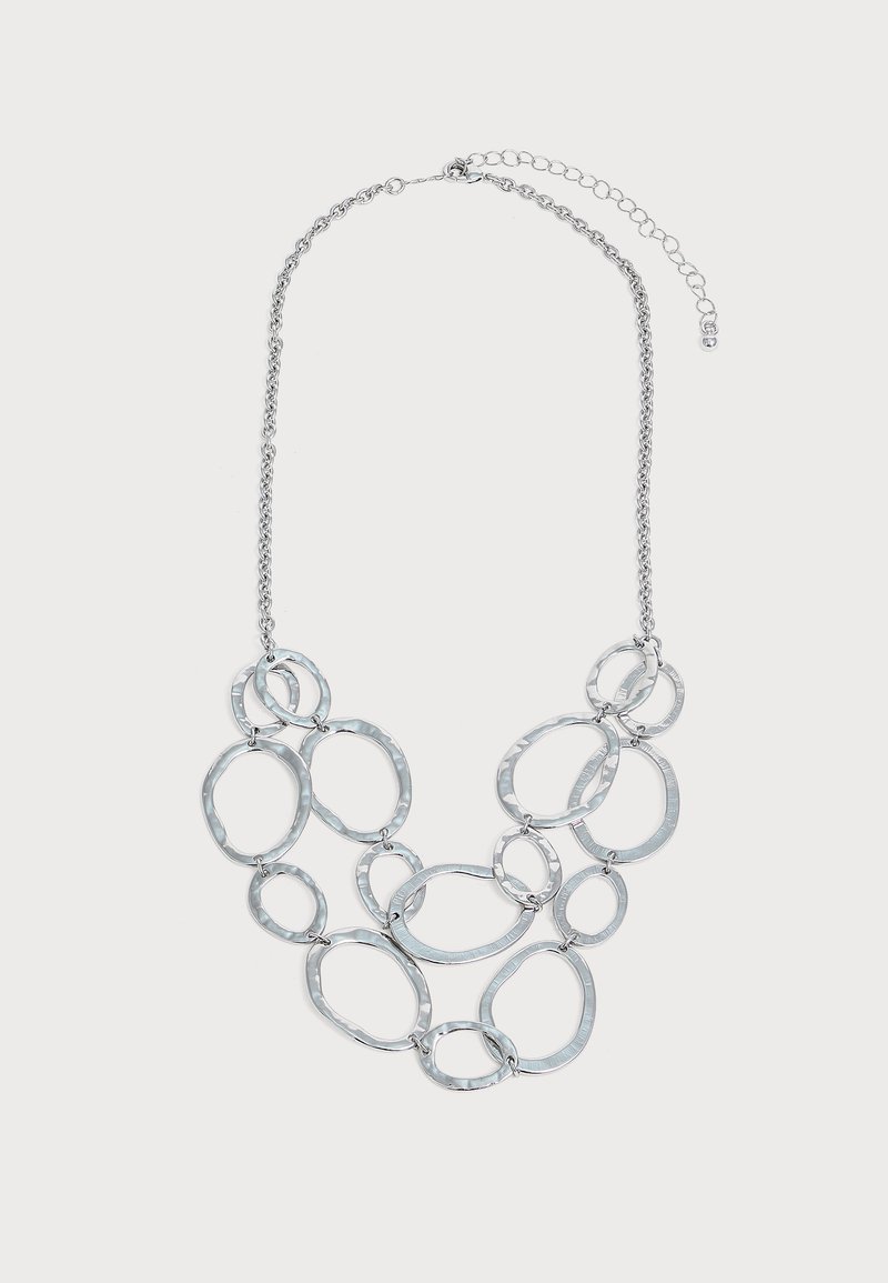 Collier chaîne en argent avec plusieurs anneaux métalliques martelés de forme ovale irrégulière reliés dans un design superposé et fermoir réglable.