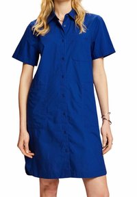 Abito con maniche corte e bottoni in cotone blu reale vivace. Presenta una tasca sul petto e un design rilassato e dritto.