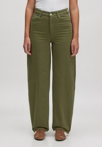 Wijdvallende olijfgroene jeans van een katoenmix. Voorzien van voorzakken, ritssluiting en knoopsluiting. Zachte textuur, gladde afwerking.