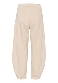 Ljust beige avspända byxor med elastisk midja, som har en slät yta och ballongformade ben som smalnar av vid ankeln.