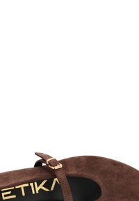 Zapato de ante marrón con punta redonda, correa al tobillo y detalle de hebilla dorada. Suela interior negra con el logo visible. Suela plana, diseño minimalista.