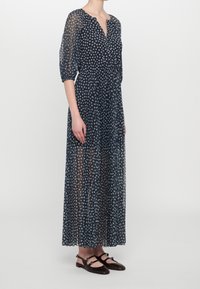 Robe midi bleu marine en tissu transparent, dotée d'un décolleté en V, de manches trois-quarts et d'un imprimé floral. Assortie avec des chaussures plates.