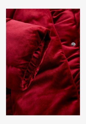 Red velvet puffer jacket featuring a plush texture, gathered sleeve detail, and a metallic snap button accent.