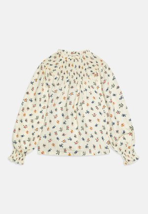 Blusa floral em creme com decote franzido e mangas longas. Apresenta pequenos padrões de flores multicoloridas e punhos elásticos. Textura de tecido suave.