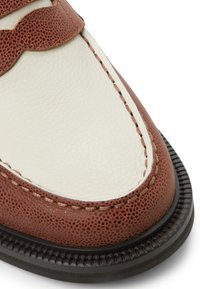 Brown textured leather shoe with a white leather section, contrasting stitching, and a round toe. Features a ridged black rubber sole.